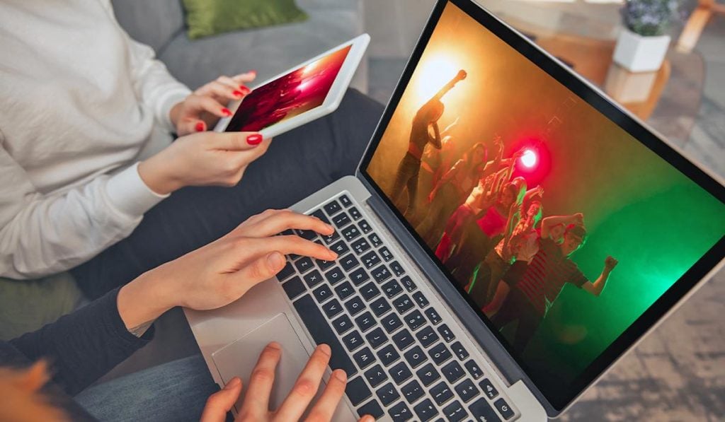 Duas pessoas uma usando um computador portátil e a outra usando um tablet