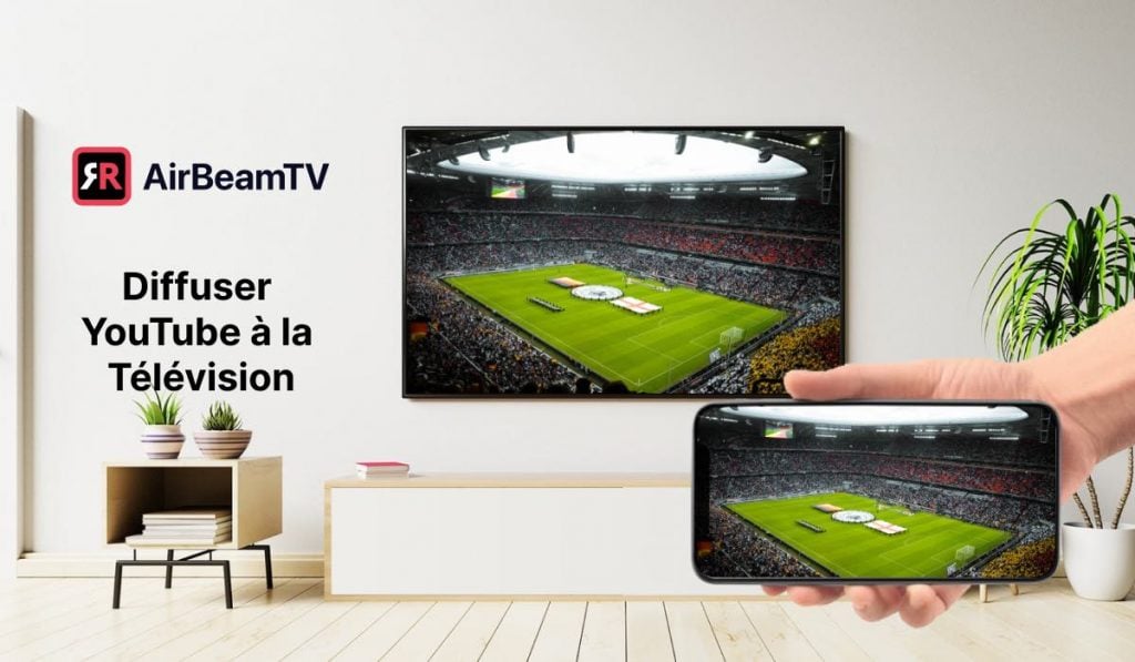 Écran reflétant l'image d'un stade depuis un smartphone vers un téléviseur. Le téléviseur est fixé au mur au-dessus d'un petit meuble. Il y a une plante sur un support décoratif et, au-dessus, l'en-tête "Cast Youtube to TV" et le logo AirBeamTV.