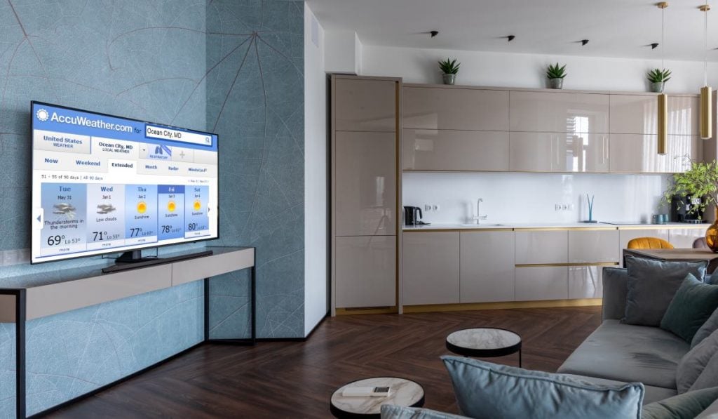 aplicativo accuweather aberto numa samsung smart tv em pé numa grande sala de estar