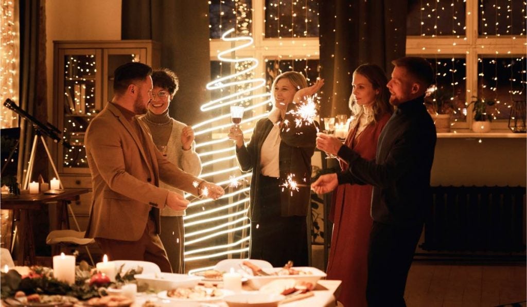 people holding fireworks and enjoying themselves at a Christmas party