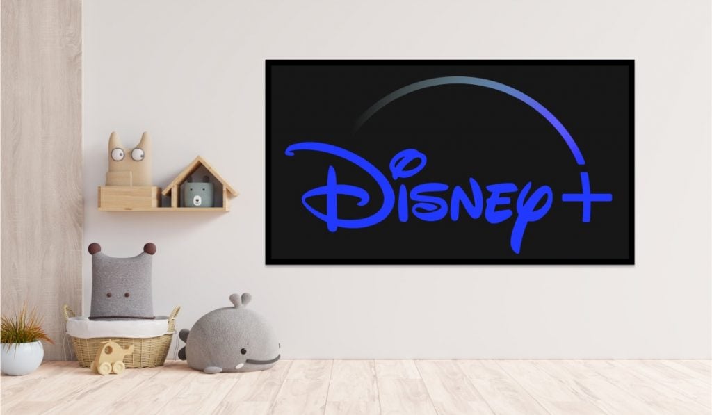 Logo Disney Plus sur une Smart TV. La Smart Tv est accrochée à un mur