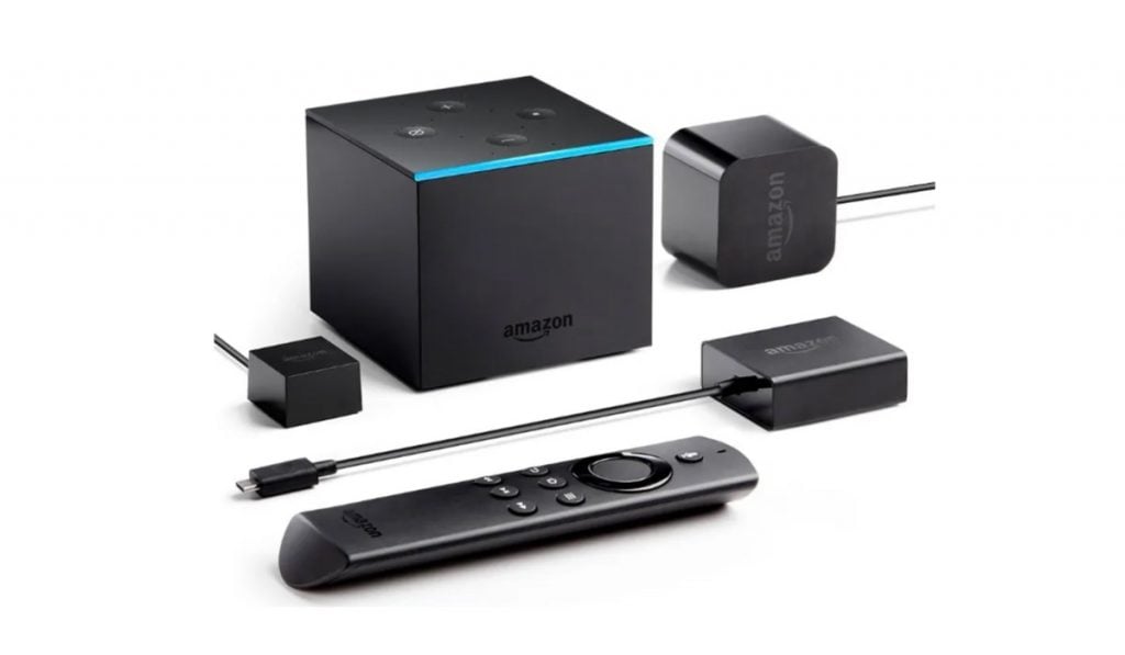 Fire Tv Cube with charging cable, power cable, remote control on white background.