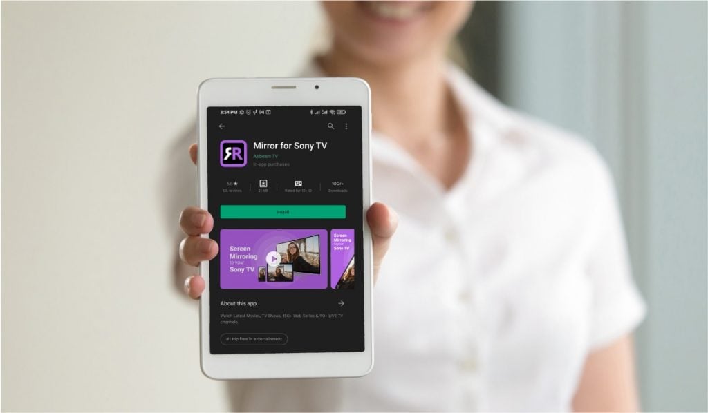 A woman holds out her hand. The is holding a smartphone with the Google Play Store page for Mirror For Sony TV app.