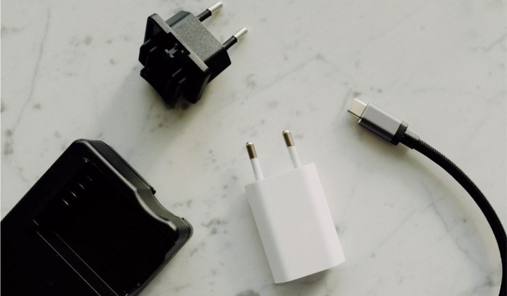 An adapter, a charging cube and a charging cable on white surface