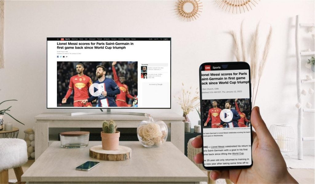 A Smart TV and a smartphone both displaying the CNN story about a goal scored by Leo Messi. There is a hand that is holding the smartphone.