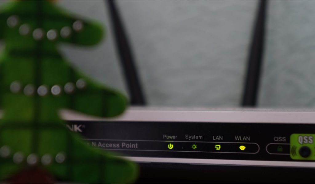 A router with blinking lights and two antennas.