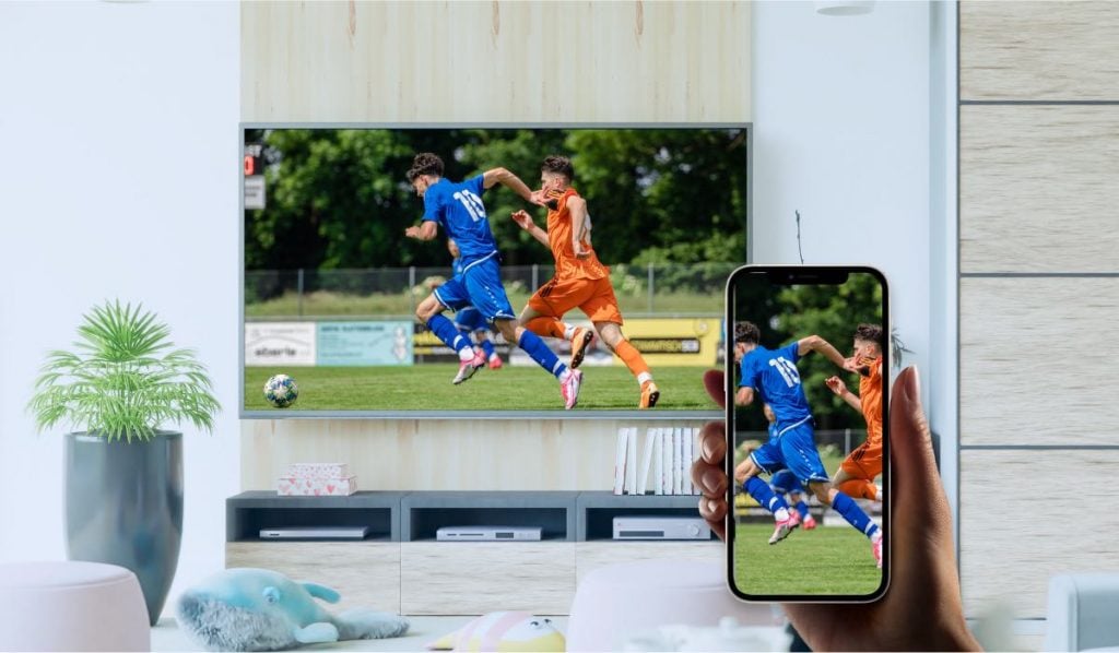 iPhone screen mirroring to Philips TV in a modern living room that displays two men playing football.