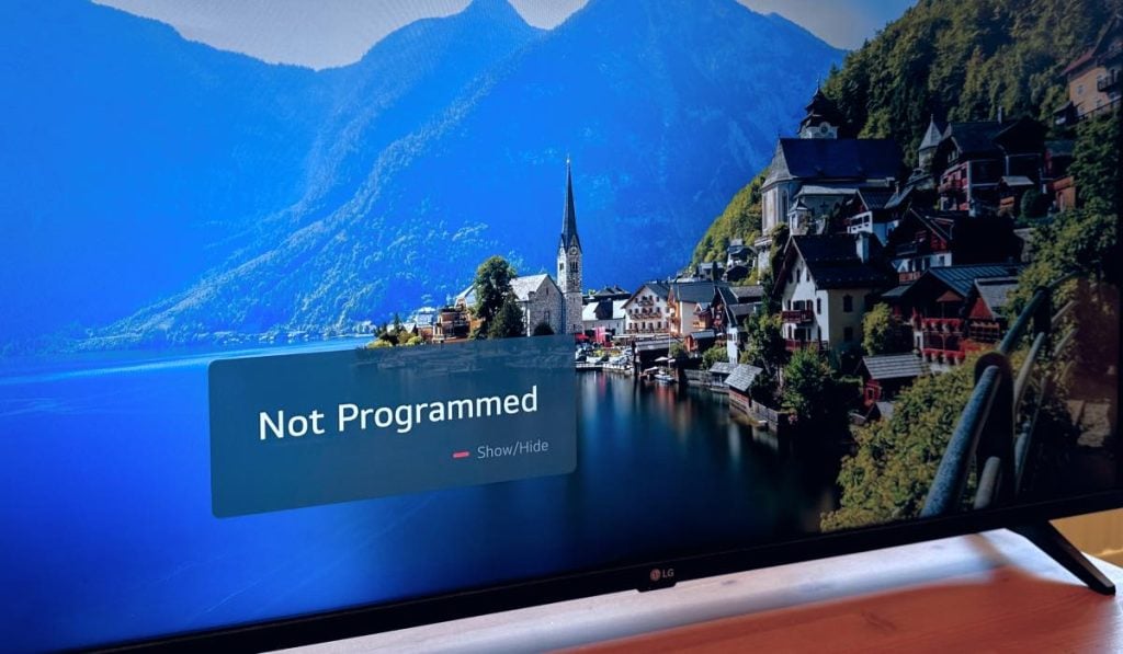 Lg TV with a screensaver and a 'Not Programmed' pop-up message on the screen