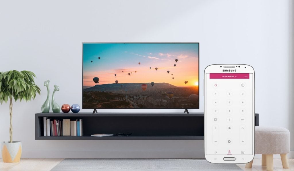 In a contemporary setting, an LG TV graces a drawer. The room's modern ambiance complements the scene. Nearby, a white Samsung smartphone proudly displays the LG TV Remote Control Plus + app interface on its screen.