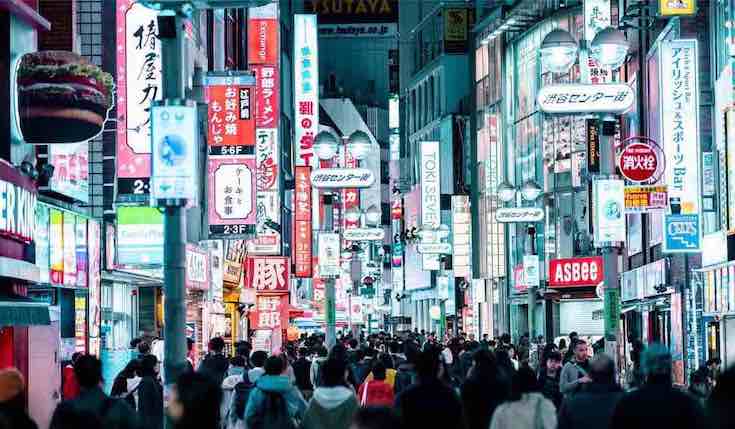a busy street in Tokyo with billboards, ads and people