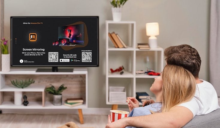 Two people embracing on a couch in a living room. They are watching TV that has the AirBeamTV Fire TV Android App banner on the screen. There are shelves around the TV