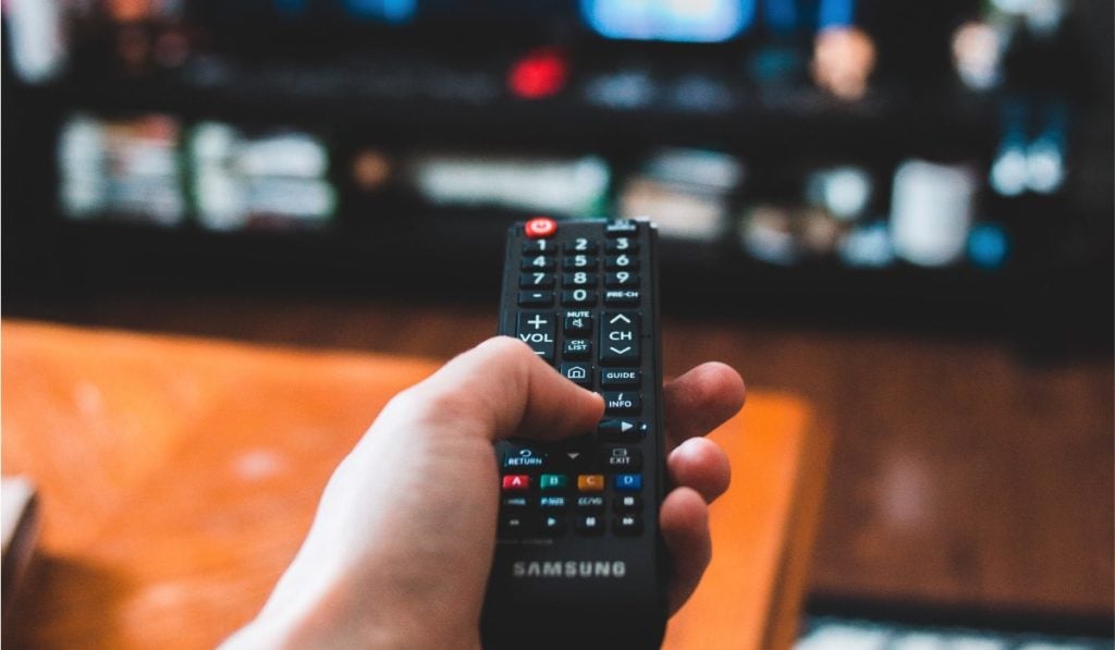 person pointing at a samsung tv with a Samsung tv remote