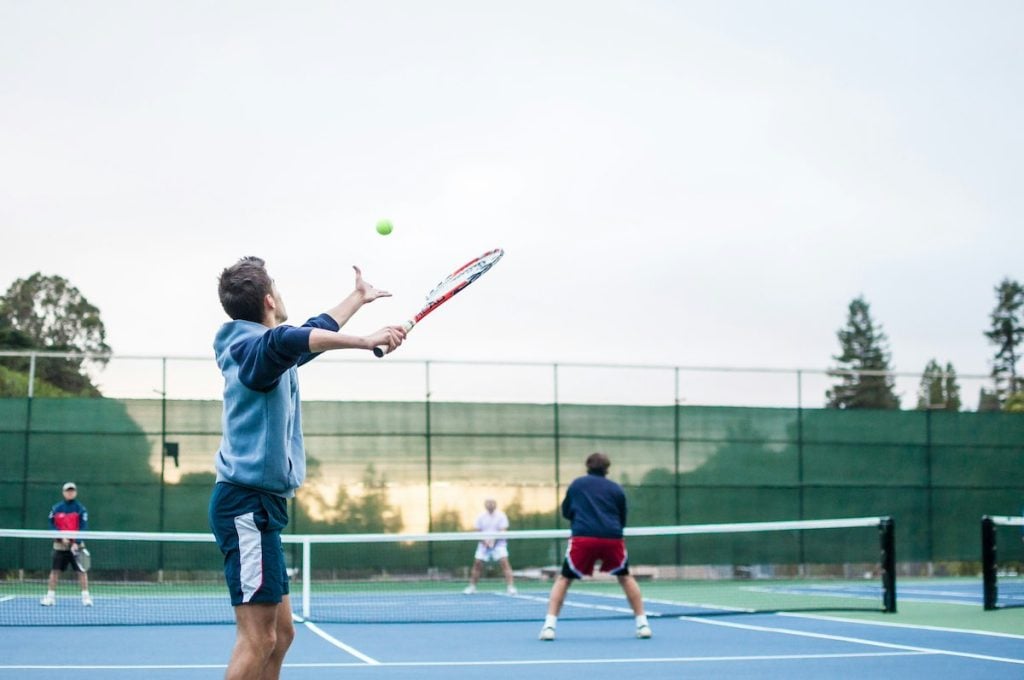 Man preparing to serve ball on a tennis court
